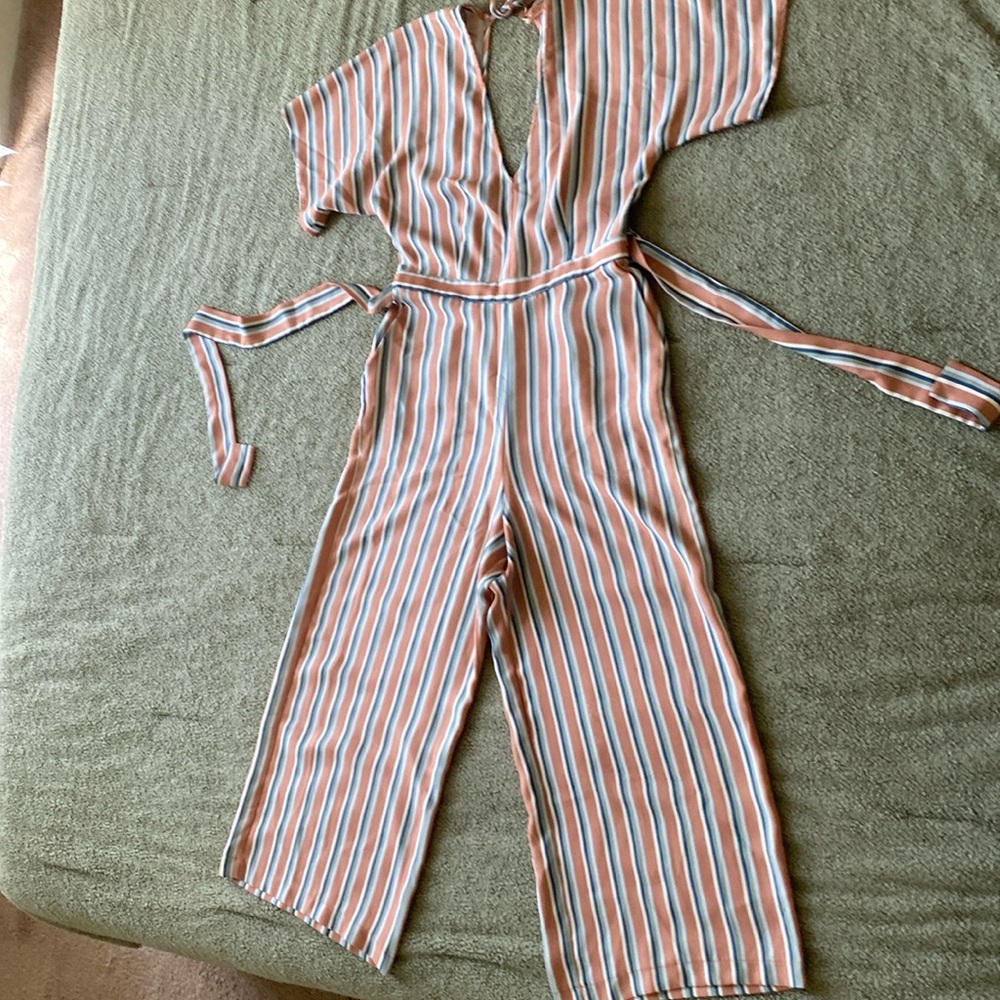 Stripped jumpsuit with pockets and back cutout. Minor pulled strings